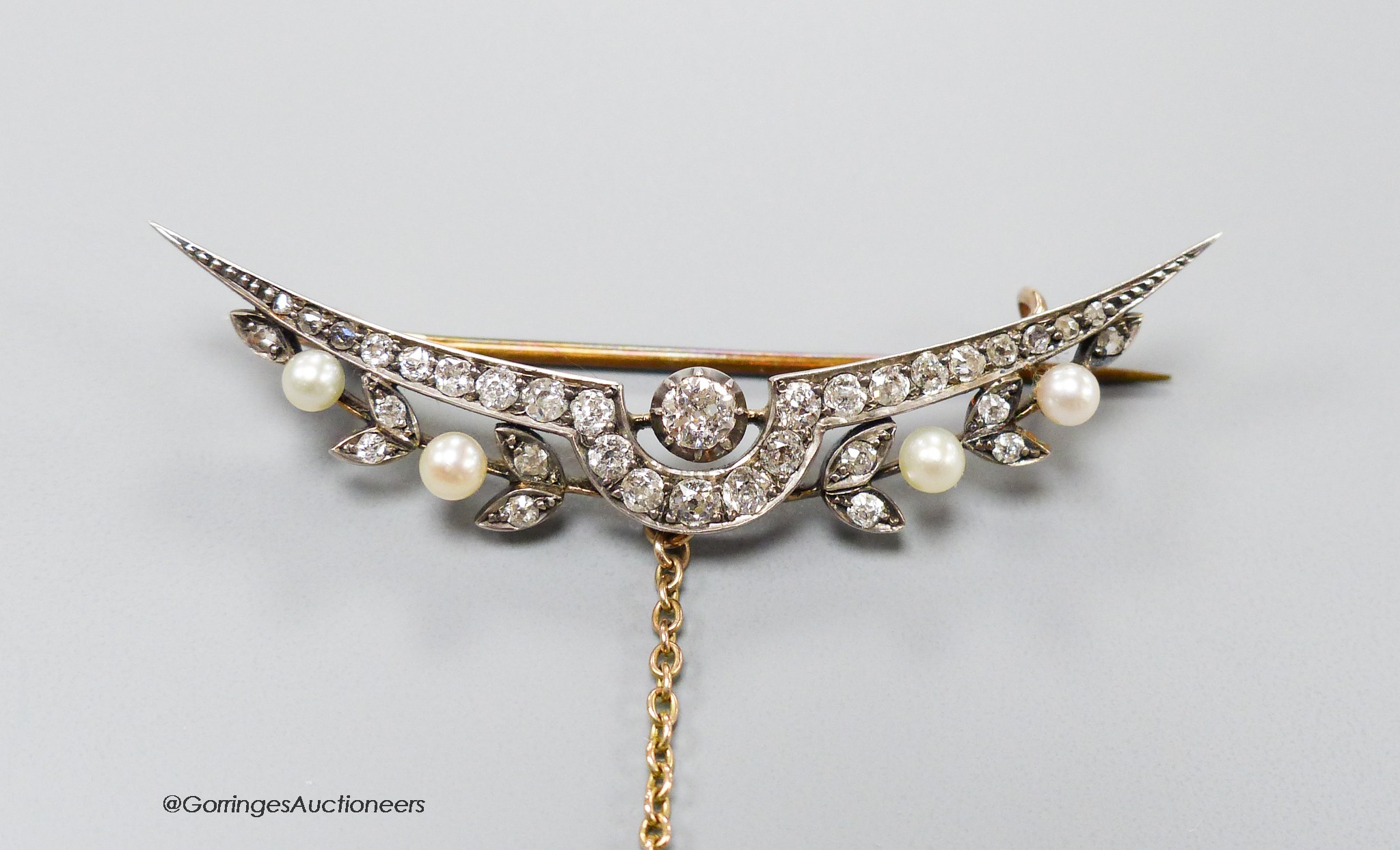 A Victorian yellow metal, diamond and seed pearl set demi-lune brooch, 55mm, gross 6.3 grams.